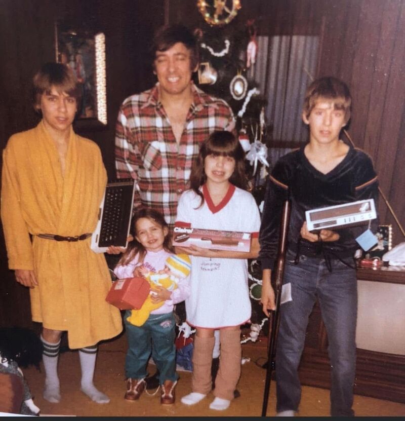 Christmas morning, early 1980s. Billy Thomas as a kid in a yellow robe, holding the Tandy computer that would become the start of his data career.